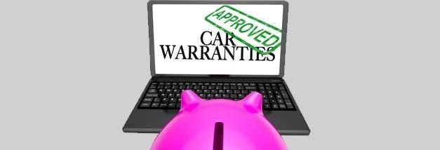 A pink piggy bank is sitting in front of a laptop computer.